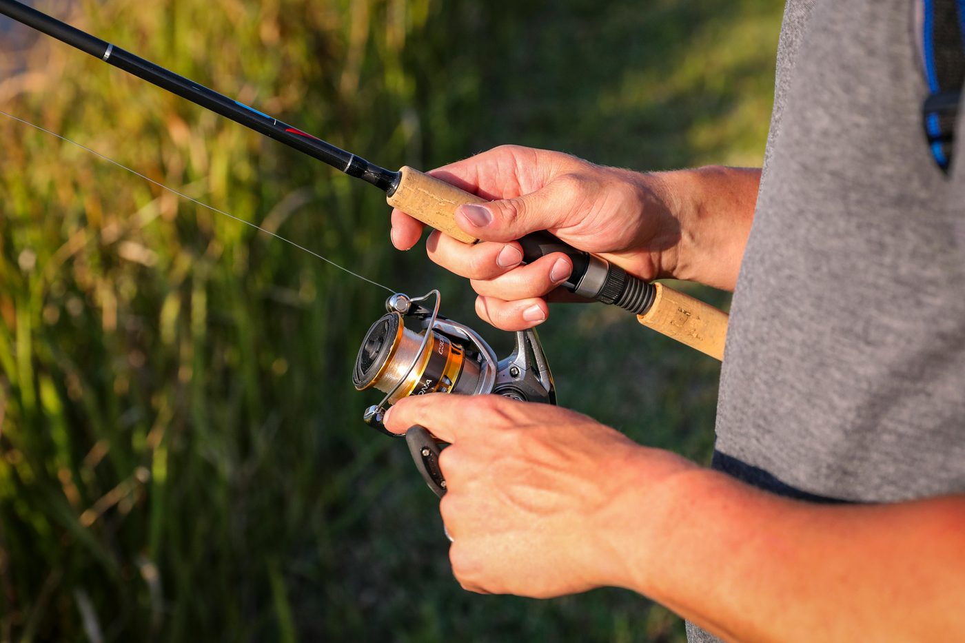 Caña de pesca spinning junto al agua