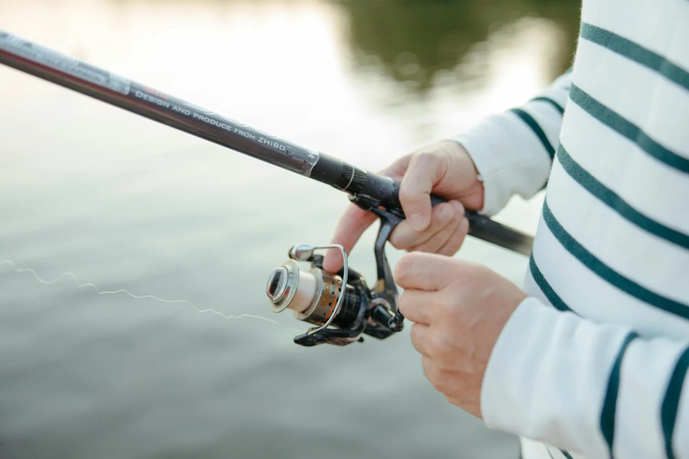 Equipo de spinning y documentación preparados antes de una salida de pesca en España
